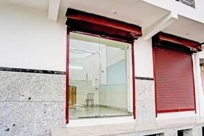 A building entrance with a glass door and a red shutter. - HOtel O The Clarks Inn (Noida)