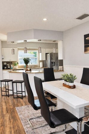 A modern kitchen with white cabinets, stainless steel appliances, and pendant lighting. - Spacious 5-bedroom house in wonderful Brandon with a wonderful Pool. (Brandon)
