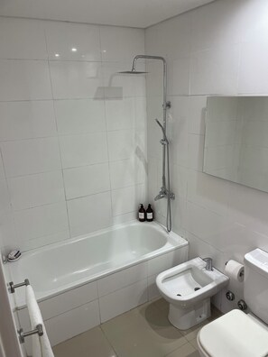 A modern bathroom with a bathtub, a bidet, and a toilet. - New Listing (Buenos Aires)