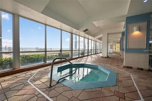 A swimming pool with a view of the beach, large windows, and a tiled floor. - Studio Beach Access Studio Kitchen Amazing Location (Daytona Beach)