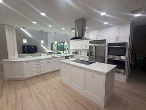 A modern kitchen with white cabinetry, stainless steel appliances, and a central island. - Lovely newly remodeled 3-bedroom, 3 bath house in charming Bonita Springs (Bonita Springs)