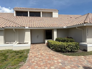 A residential building with a tiled roof, a front door, and a brick pathway leading to the entrance. - Lovely newly remodeled 3-bedroom, 3 bath house in charming Bonita Springs (Bonita Springs)