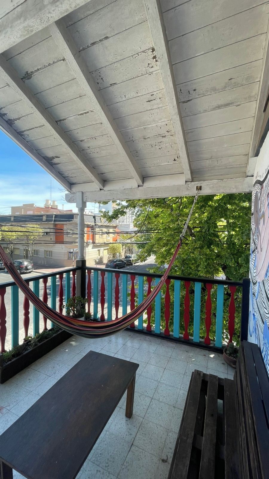Un espace extérieur abrité, doté d’un hamac, d’un banc et offrant une vue sur le paysage urbain.