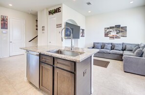 A modern kitchen with a built-in dishwasher, a granite countertop, and a stainless steel sink. - Elegant 3BR Townhome Private Yard & 2-Car Garage (Richmond)