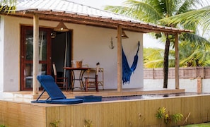 A covered outdoor area with a pool, lounge chairs, and a dining table. - New Listing (Japaratinga)