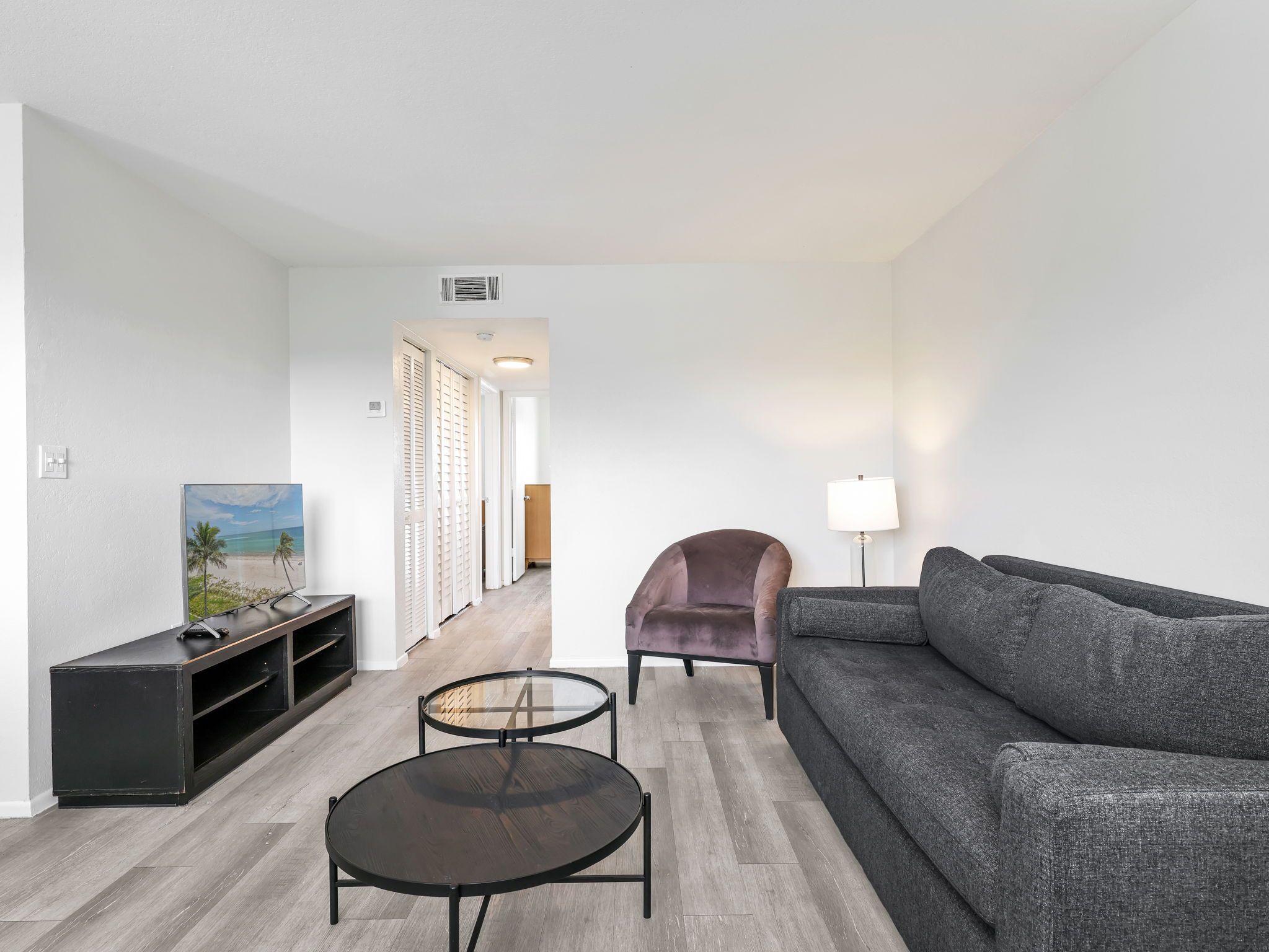 Ein modernes Wohnzimmer mit Sofa, Sessel, Couchtisch und TV-Möbel.