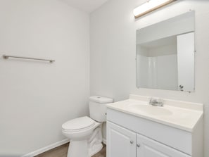 Ein Badezimmer mit Toilette, Waschbecken und Spiegel.