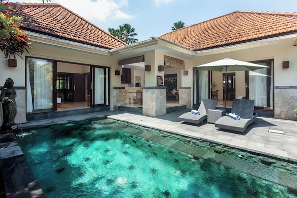 A poolside area with lounge chairs and a covered seating area. - Kadiga Villas - 2 BR pool Villa (Bali)