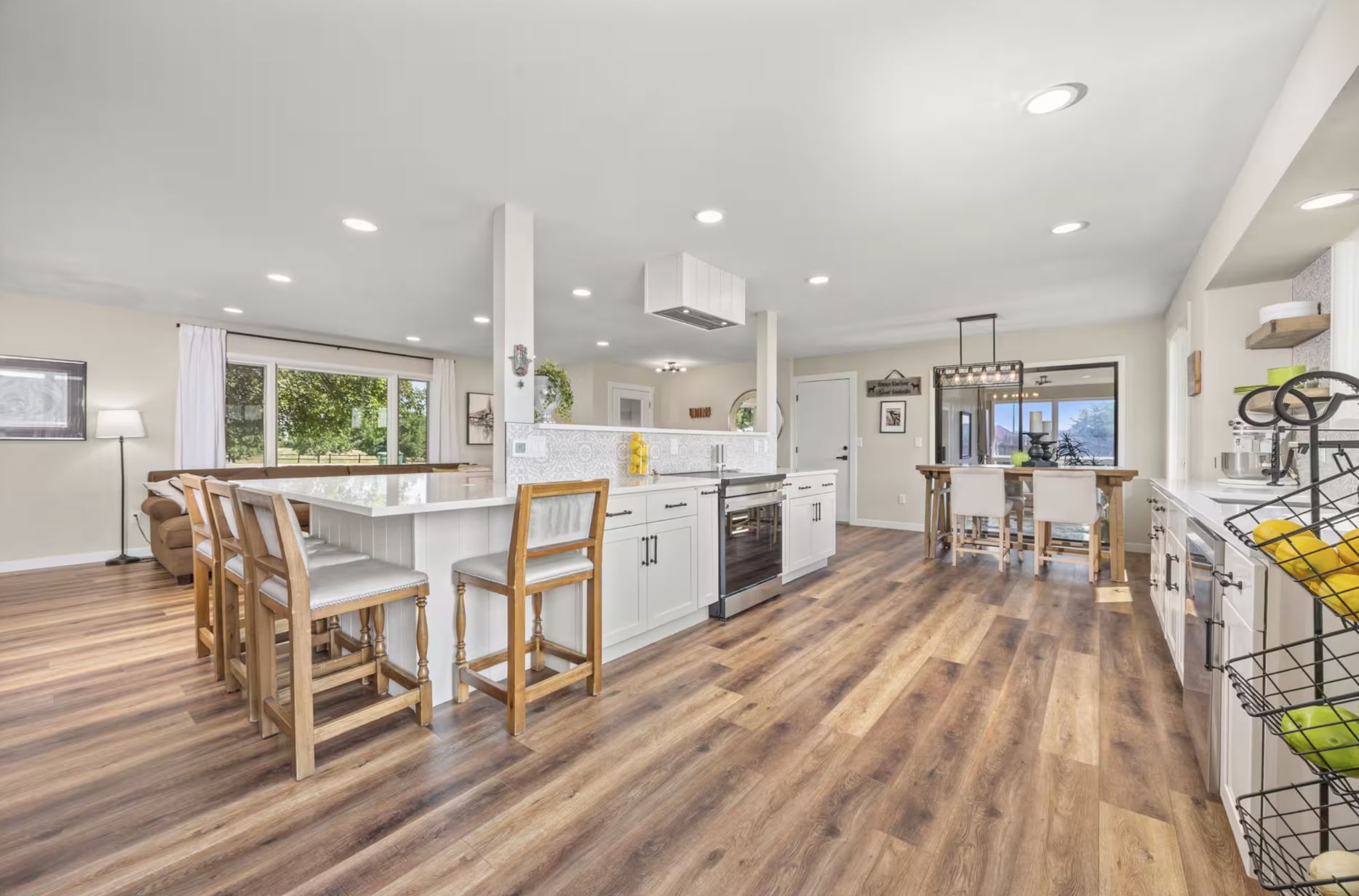 A spacious kitchen with a central island, wooden flooring, and modern cabinetry.