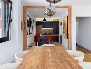 Una cocina moderna con armarios oscuros, una isla central y una lámpara colgante.