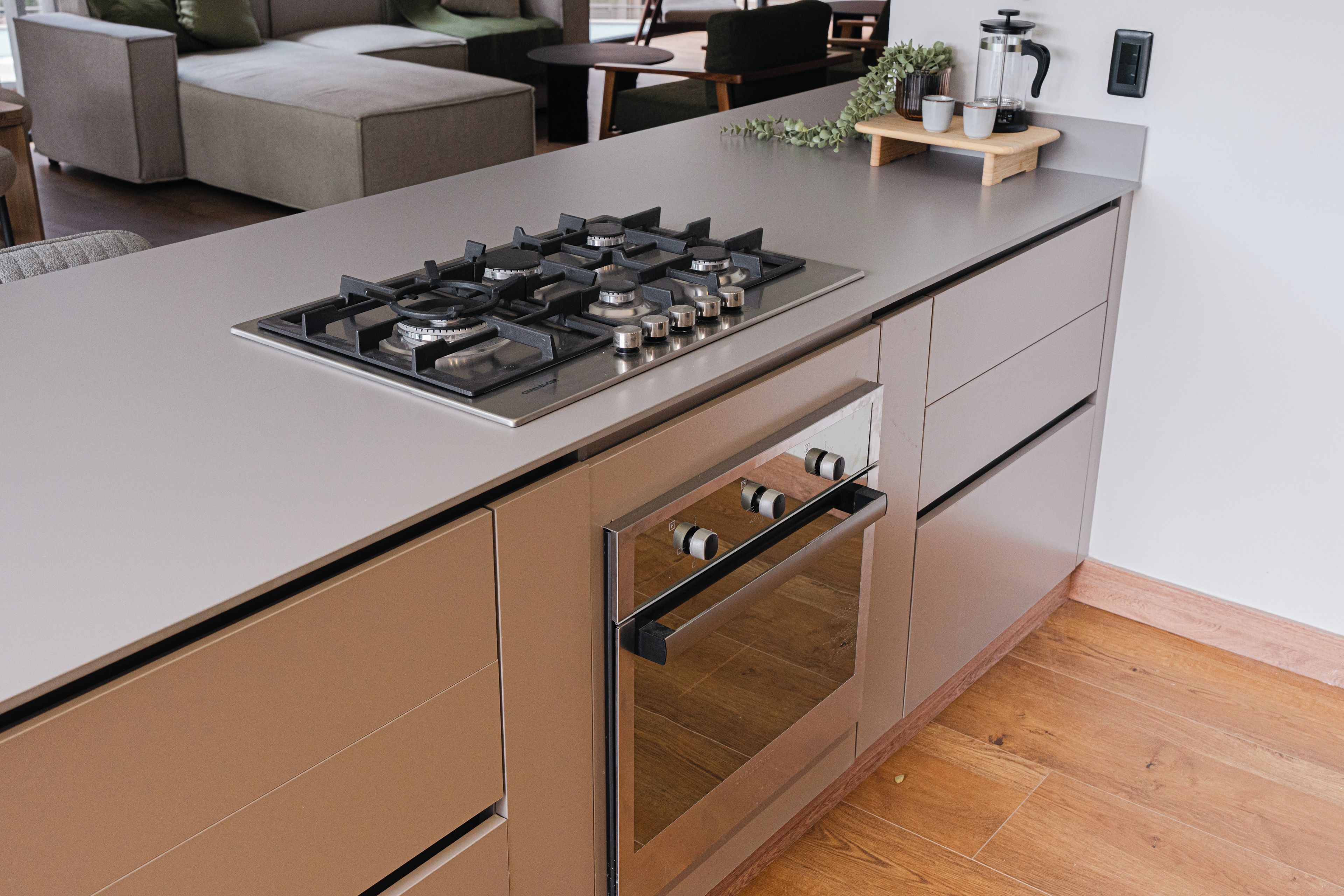 A modern kitchen with a gas stove, oven, and a wooden countertop.