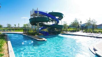 Une piscine avec un toboggan et des bouées gonflables.