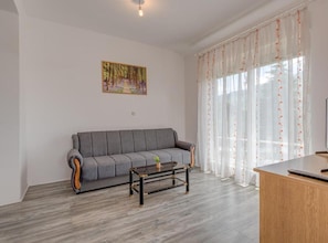 A living room with a grey sofa, a coffee table, and a painting on the wall. - Beautiful Rustic Relax Villa (Dugopolje)