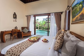 Ein Hotelzimmer mit Bett, Schreibtisch und Blick auf einen Swimmingpool.