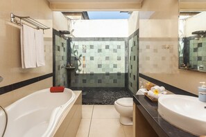 Een moderne badkamer met een bad, toilet en wastafel.