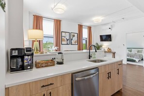 Eine moderne Küche mit Kaffeemaschine, einer Kaffeebar-Beschilderung und einem Spülbecken.