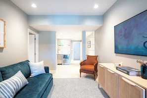 A modern living room with a sofa, a chair, a coffee table, and a bookshelf. - Newly Renovated Annapolis Escape with Pool, Hot Tub & Sauna (Annapolis)