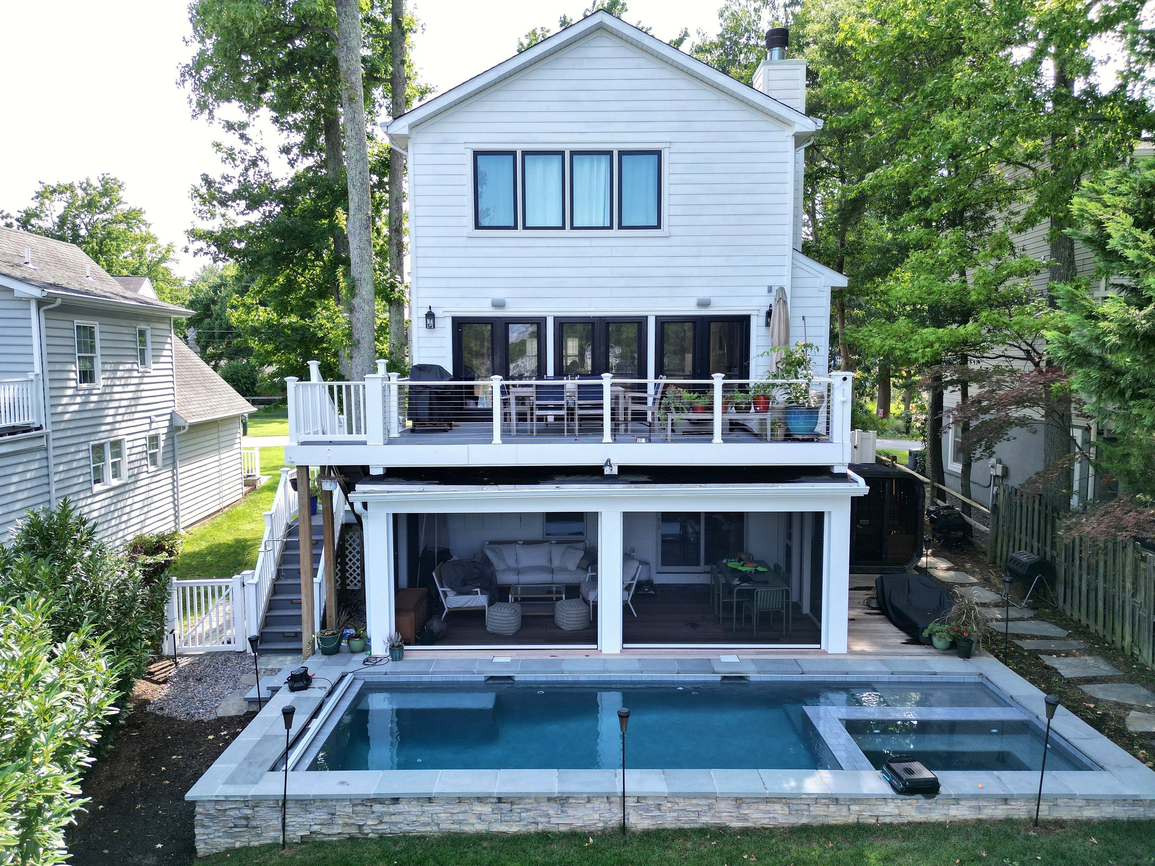 A two-story house with a balcony, a swimming pool, and a backyard.