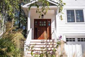 A two-story house with a front porch, a wooden door, and a garage. - Newly Renovated Annapolis Escape with Pool, Hot Tub & Sauna (Annapolis)