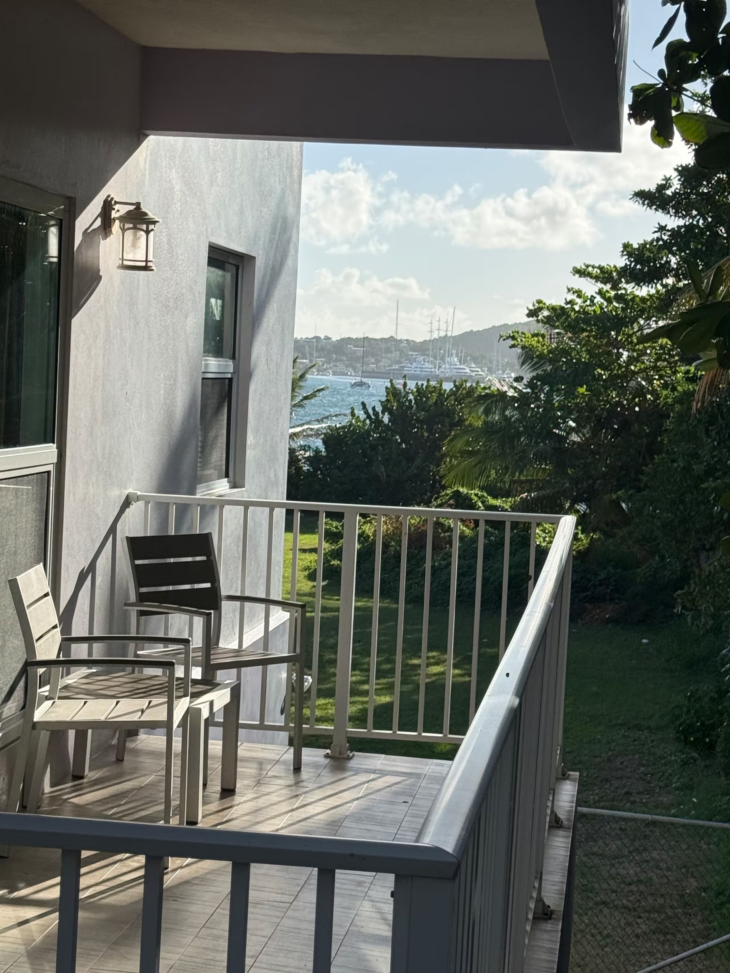 Een balkon met buitenmeubilair en uitzicht op een jachthaven.