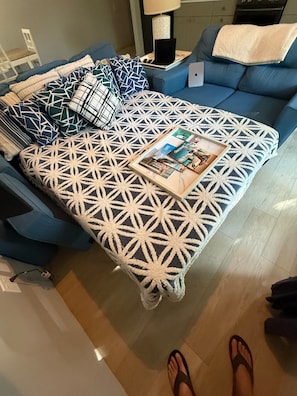 A bed with a geometric patterned bedspread, a laptop on a side table, and a magazine on the bed. - Luxurious Beach Front Villa Pool-Gym-AC Sleeps 5! (Turtle Bay)