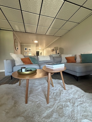 Ein modernes Wohnzimmer mit einer Eckcouch, einem Couchtisch und einem Teppich.