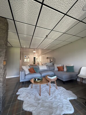 A modern living room with a sectional sofa, a white furry rug, and a coffee table. - Your Perfect Snowshoe  Getaway make most of the mountains in this stylish condo! (Snowshoe)