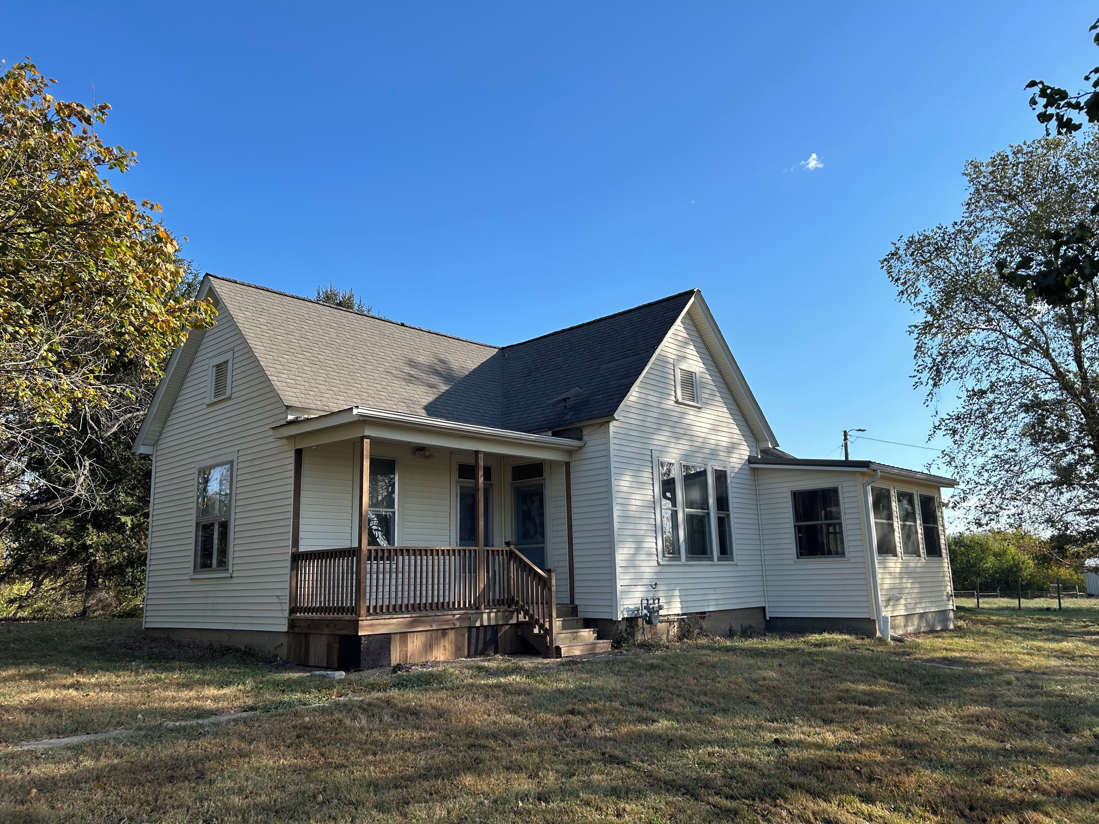 A single-story house with a porch, a small attached garage, and a sloped roof.