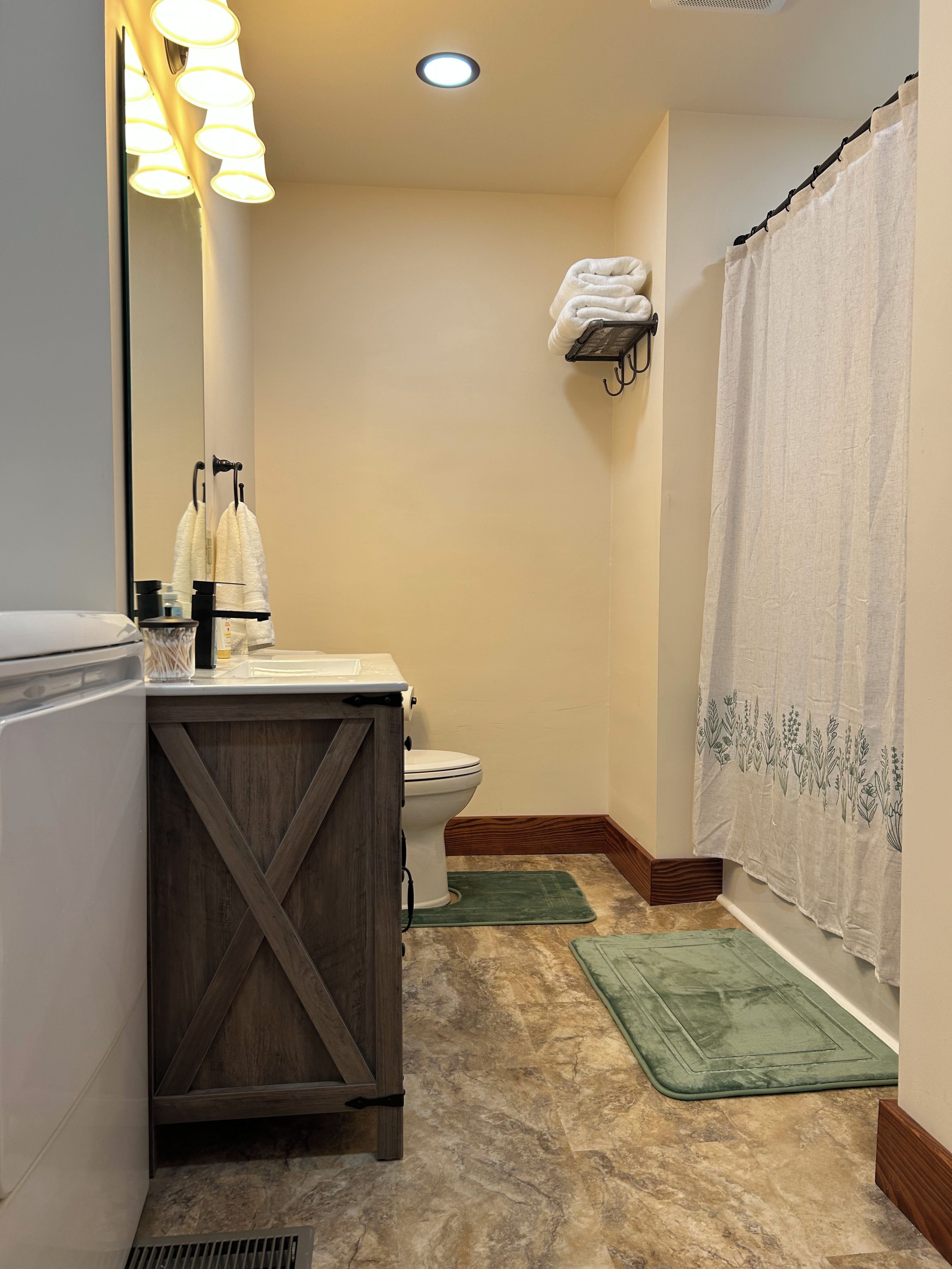 Een badkamer met toilet, wastafel en douchegordijn.