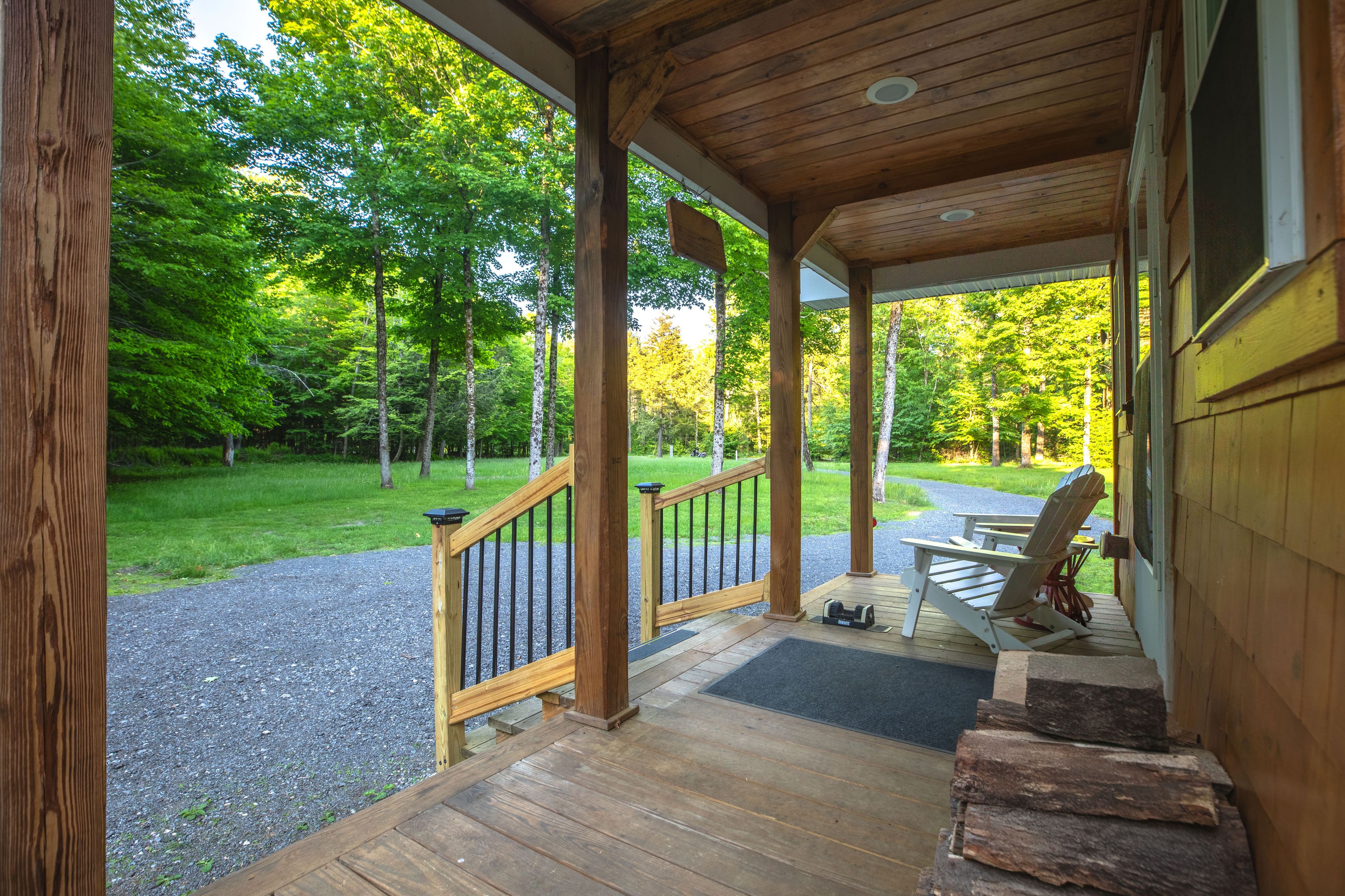 A wooden porch with a view of a forested area.