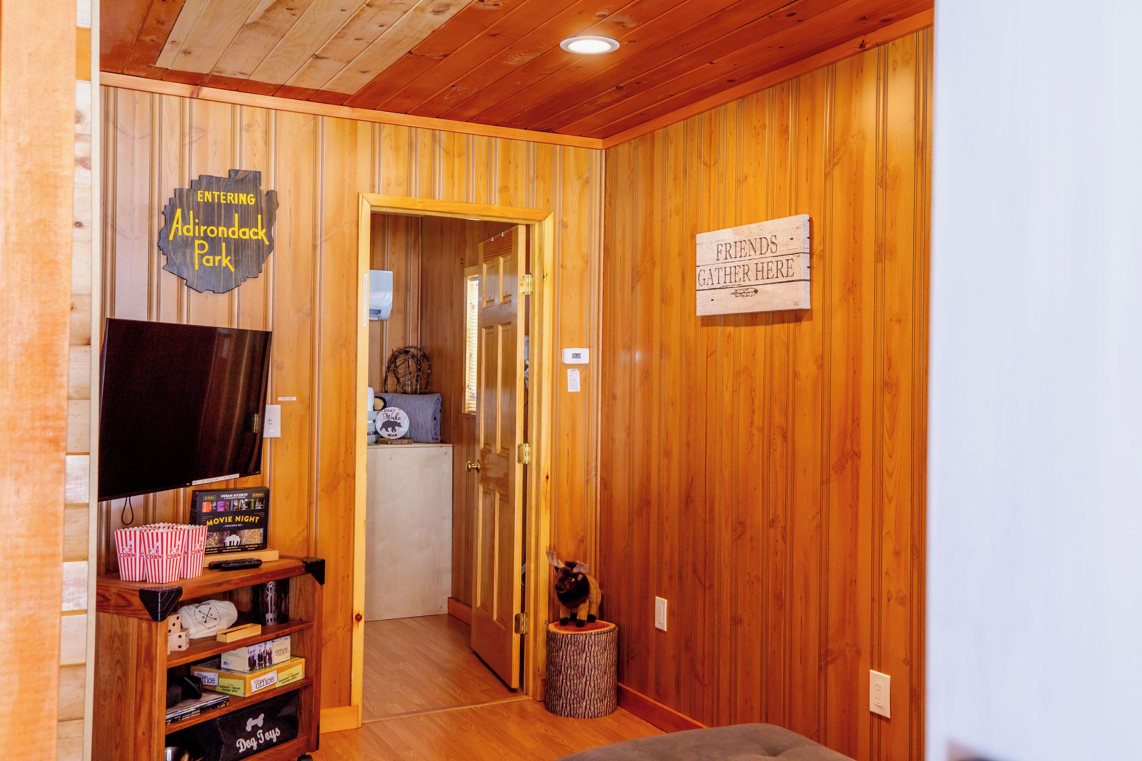 Un interior de madera con televisión, palomitas de maíz y un cartel que indica un espacio para reuniones.