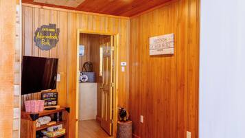Un interior de madera con televisión, palomitas de maíz y un cartel que indica un espacio para reuniones.