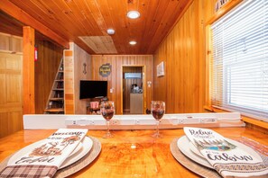 A wooden interior with a reception desk, two wine glasses, and a welcome mat.