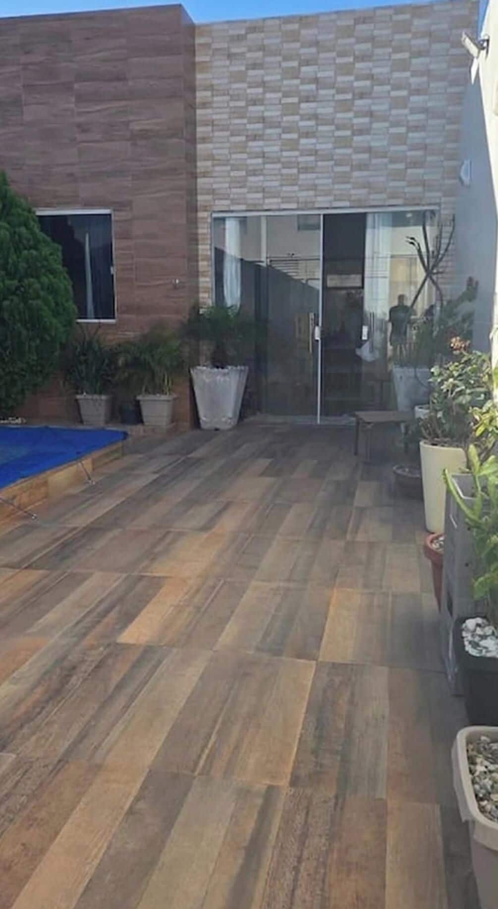 Un bâtiment moderne avec une façade en bois, une entrée dotée d’une porte en verre et une terrasse en bois.