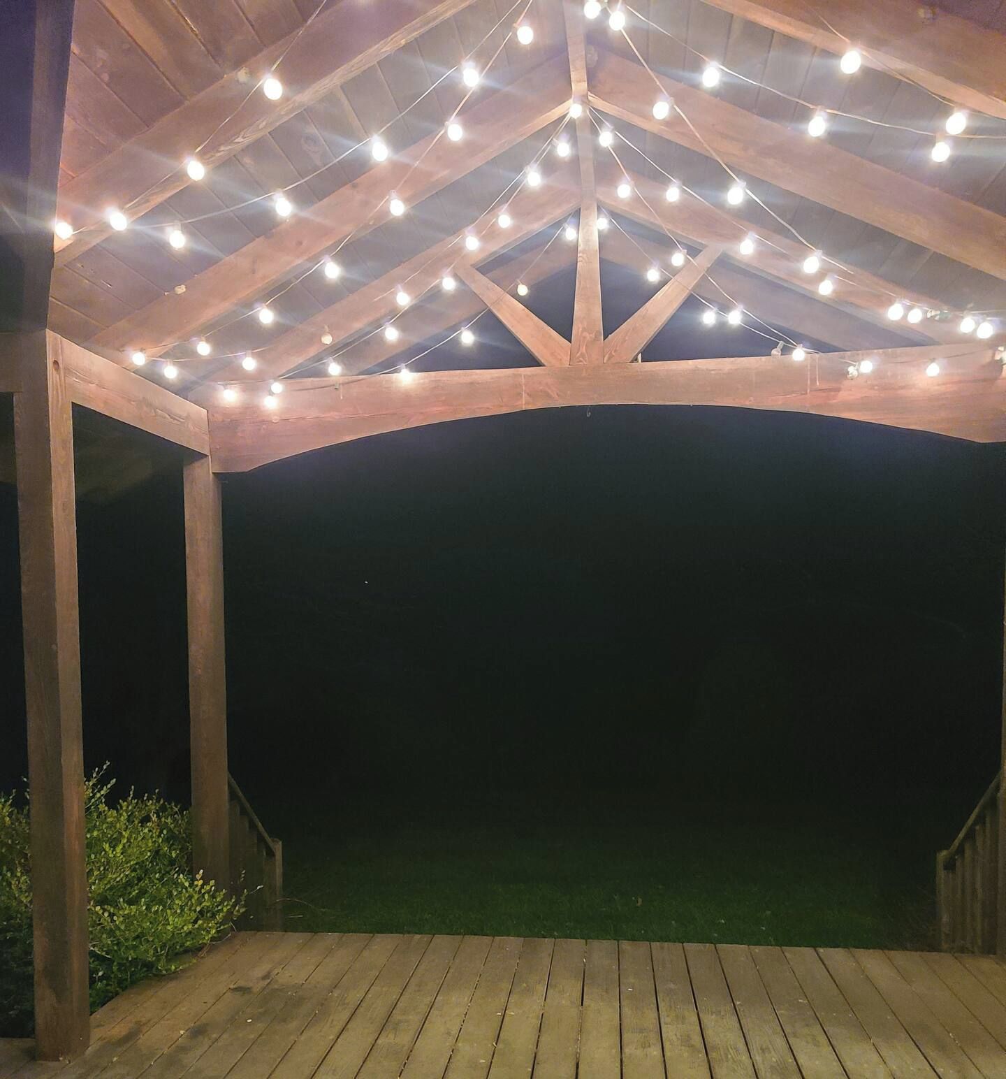 A covered outdoor area with wooden beams and string lights.