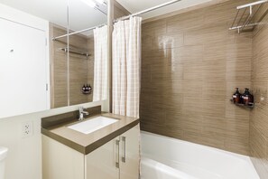 Ein modernes Badezimmer mit großem Spiegel, Waschbecken und Badewanne.