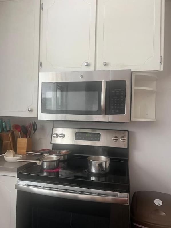 A kitchen with a microwave, oven, and stovetop.