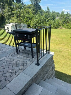 A barbecue grill on a patio with a metal railing and steps leading down to a grassy area. - Welcome to a brand new, inviting 3-bedroom, 2-full bath in Augusta, Ga (Augusta)