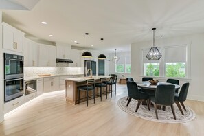 A modern kitchen with white cabinetry, a central island, and bar stools. - Welcome to a brand new, inviting 3-bedroom, 2-full bath in Augusta, Ga (Augusta)