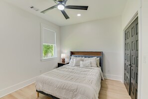 A bedroom with a bed, a nightstand, a lamp, a ceiling fan, a window, and a door. - Welcome to a brand new, inviting 3-bedroom, 2-full bath in Augusta, Ga (Augusta)