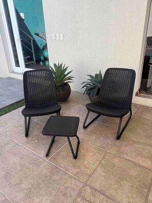 Two wicker chairs and a small table on a tiled patio. - Private Pool House in Oaxaca (Oaxaca de Juárez)