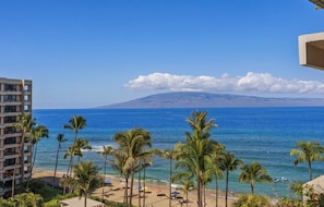 A beach view with palm trees, a clear sky, and a mountain in the distance. - Kaanapali Alii - 4 BR (2 condos), Sleeps 12 (Lahaina)