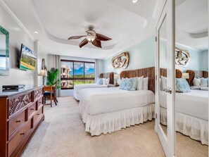A hotel room with two beds, a desk, a chair, a ceiling fan, and a large window offering a view. - Kaanapali Alii - 4 BR (2 condos), Sleeps 12 (Lahaina)