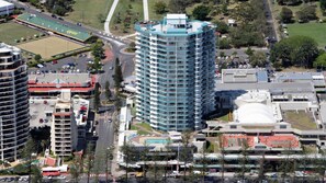 Un edificio moderno de varios pisos, rodeado de calles y otros edificios.