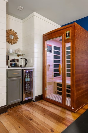 Quarto com sauna, máquina de café e um pequeno armário.