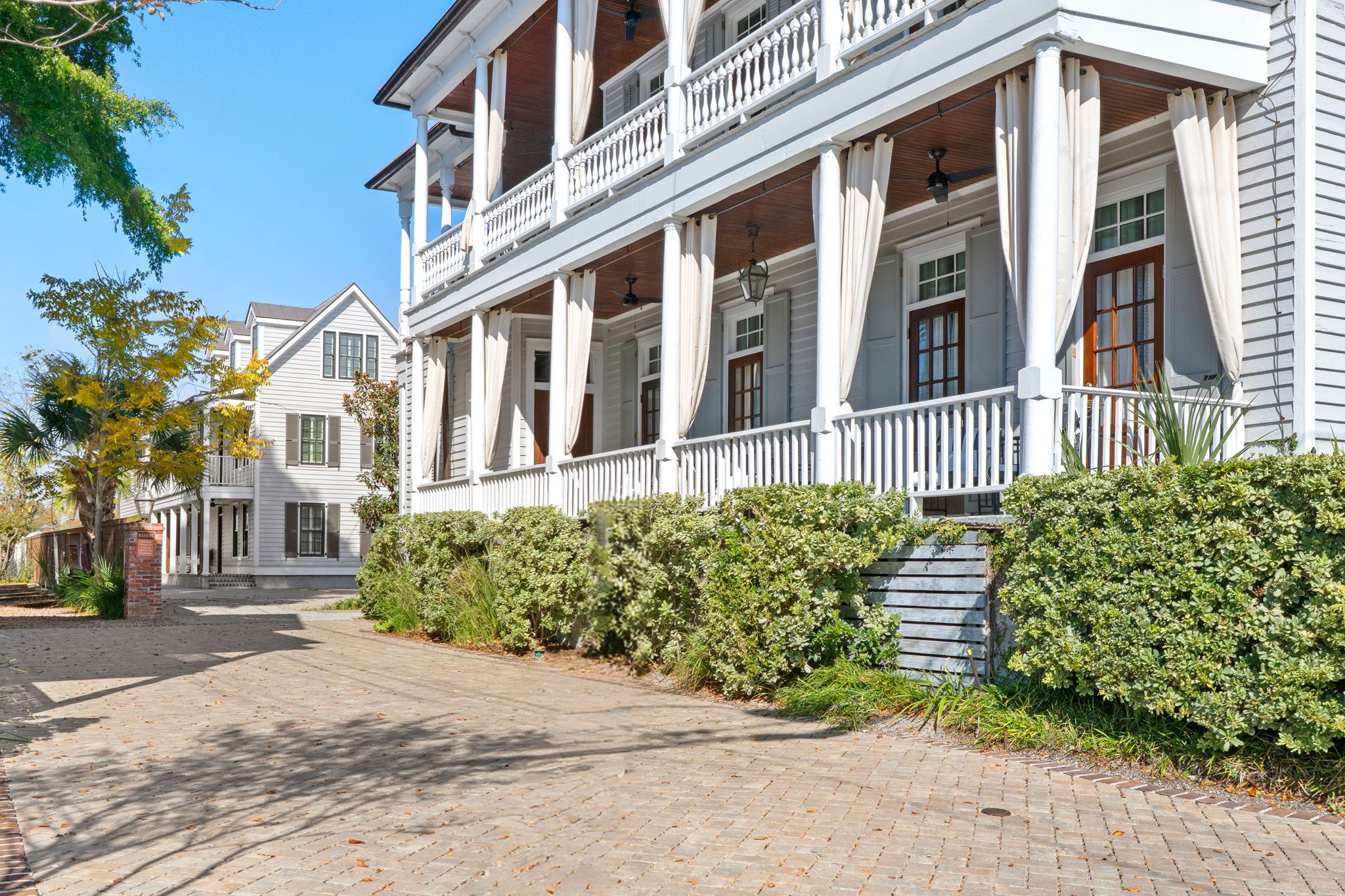 A two-story building with a covered porch and a brick pathway leading to the entrance.