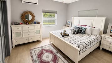 Ein Schlafzimmer mit Bett, Kommode, Schminktisch und Deckenventilator.