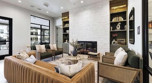 A modern living room with a fireplace, comfortable seating, and a bookshelf. - Landing Spectacular 1BD (Dripping Springs)