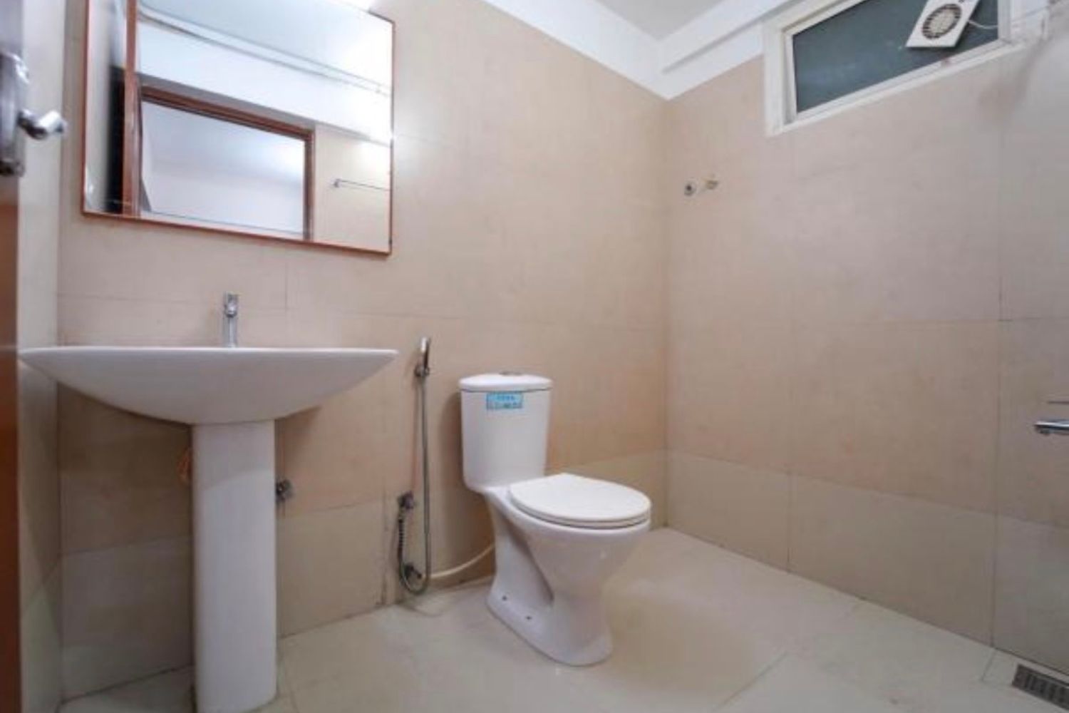 Un baño con lavamanos pedestal, inodoro y ducha.