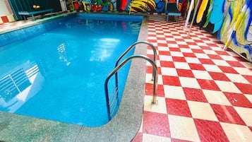 Una piscina con piso a cuadros y barandillas metálicas.